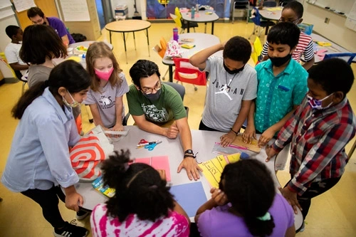 Teacher talking with students at a table