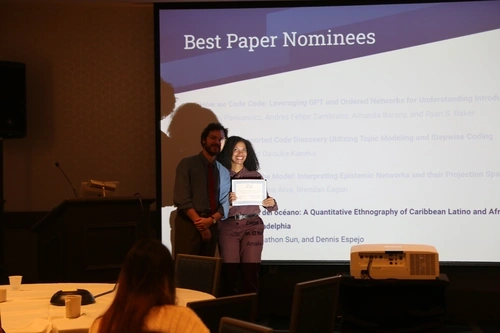 Zachary Sweicki hands Amalia Daché an award during the closing ceremony at ICQE.
