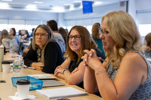 Three women smiling and participating in the PLN Leadership Summit