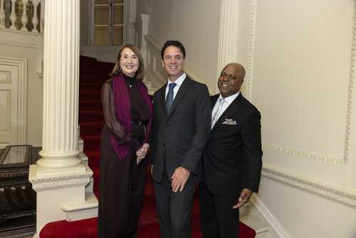 The 2025 McGraw Prize winners stand next to a column on a staircase smiling, from left: Cathy Davidson, Joe Wolf, and Frederic Bertley.