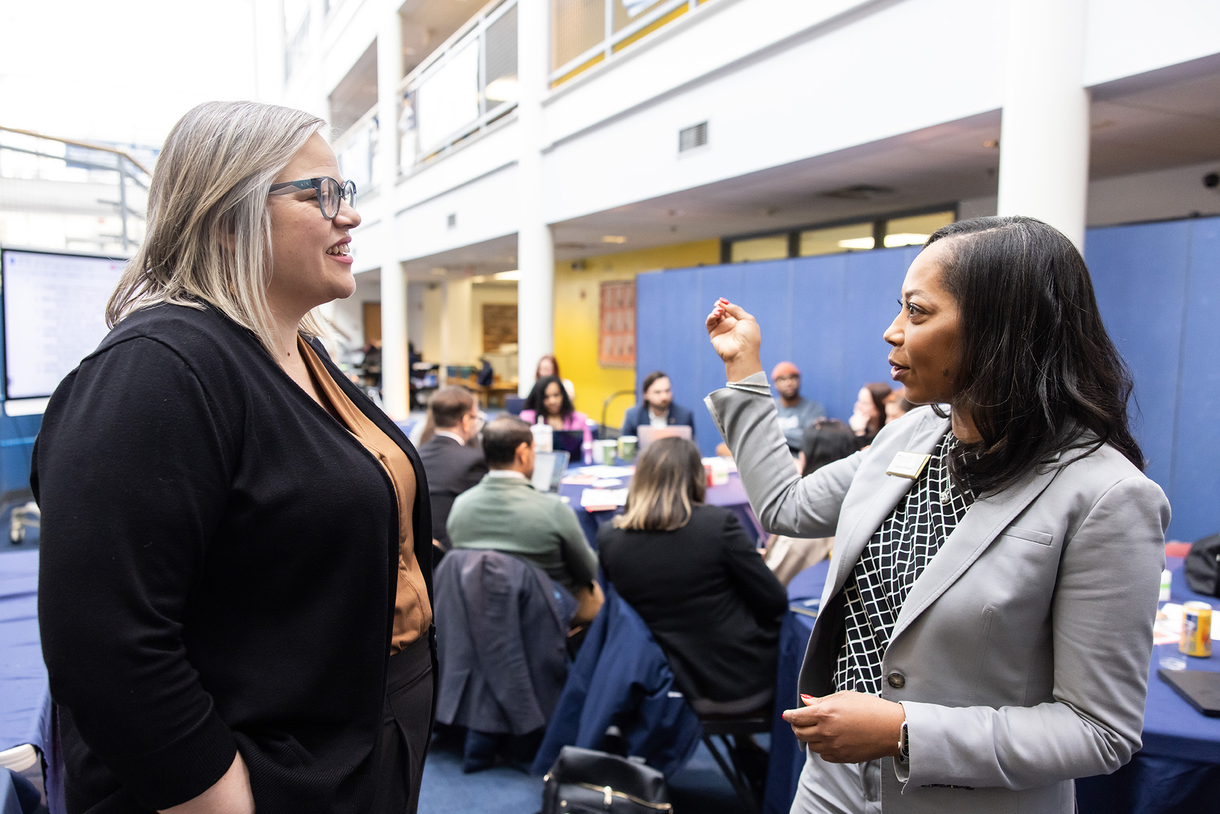 Lauren Overton (left) and Jessica Richard speak to each other amid a crowd of School Leadership students and Penn Alexander Elementary teachers.