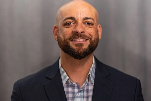 Headshot of Adam Payne with grey background