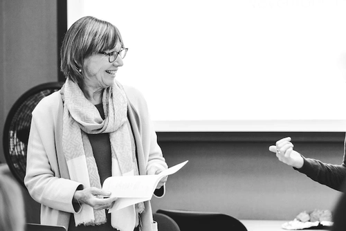 Pam Grossman holding a paper in front of a class
