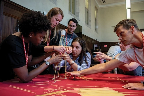 Educators compete to see which group will build the tallest tower from spaghetti.
