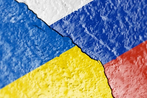 Cracked pavement with the Ukrainian and Russian flags painted on.