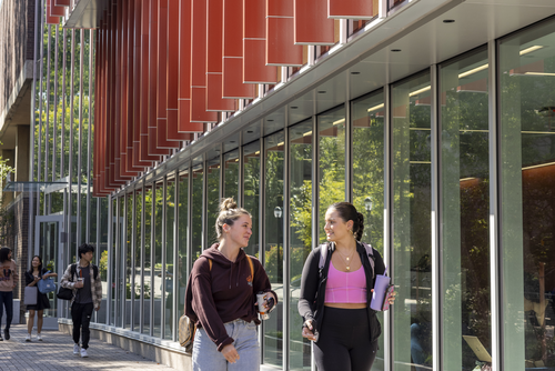 Students walking outside Penn GSE building on a sunny day
