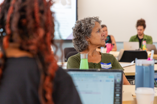 Teacher listens to AI development lecture