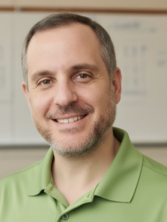 A headshot of Nick Pesola smiling and wearing a green polo shirt