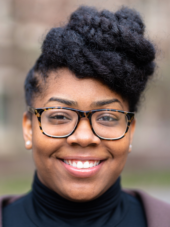 A headshot of Celine, smiling in glasses. 