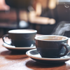 Two coffee cups on a wooden table