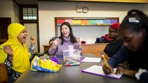 Penn GSE counseling student at General George G. Meade School in Philadelphia celebrating with middle school children