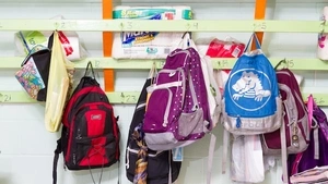 Kids' backpacks hanging on hooks