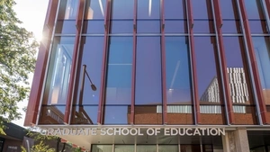 The sun flares on the front of the GSE building with the Graduate School of Education sign clearly visible