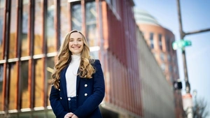 Lorea Peterson Rodondo stands in front of the Penn GSE building and Wharton's Huntsman Hall