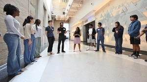 Luis and the students in his babgpt workshop stand in a horseshoe outside the Franklin Institute exhibit on The Brain