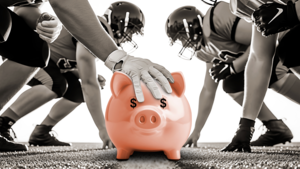 A black-and-white photo of football players in the line of scrimmage but the ball is a pink piggy bank. 